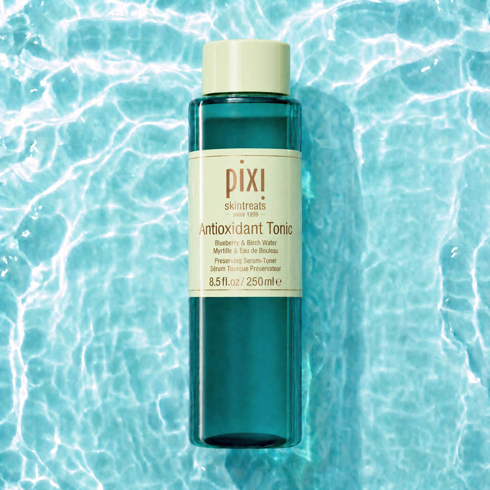 Pixi Skintreats Antioxidant Tonic in a translucent teal bottle with a cream-colored cap and label, centered against a background of rippling turquoise water. view 1