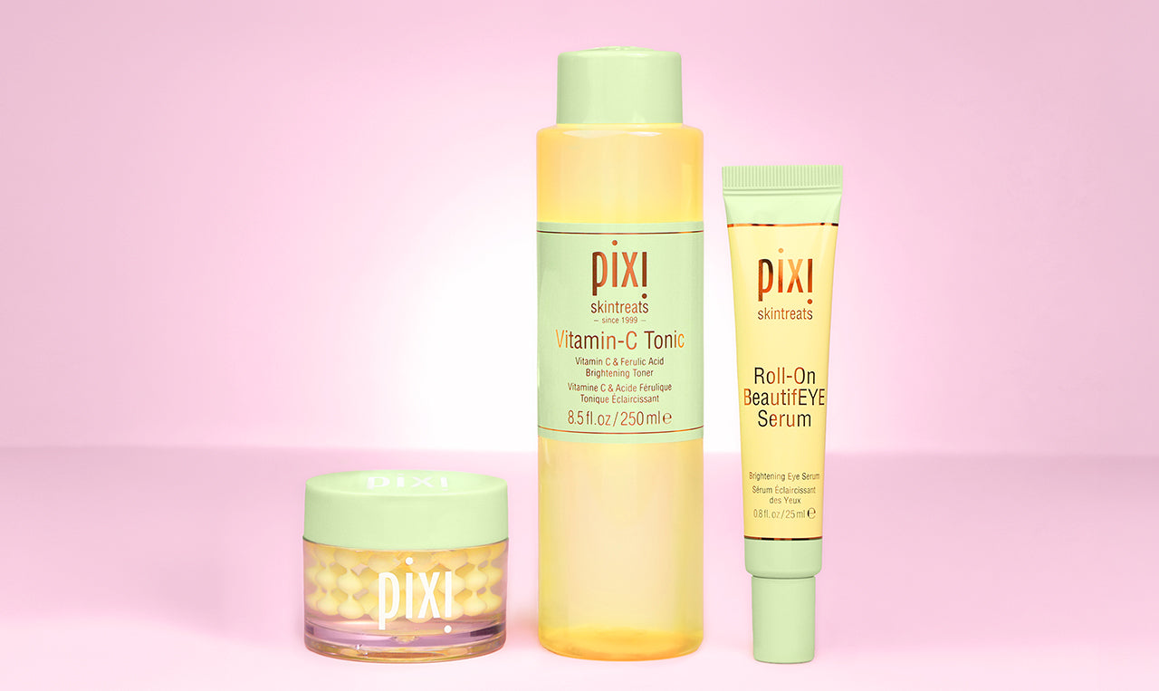 Pixi skincare products on a pink background including Vitamin-C CremeSerum, Tonic and Roll-On BeautifEYE Serum